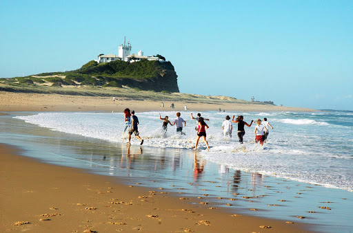 People romp through the surf at Nobbys Beach in the Newcastle region of North Coast NSW, Australia.