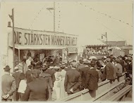 Publiek voor een kermiskraam van de sterkste mannen ter wereld