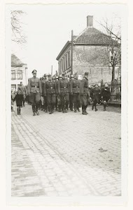 Wehrmacht militairen lopen in een straat