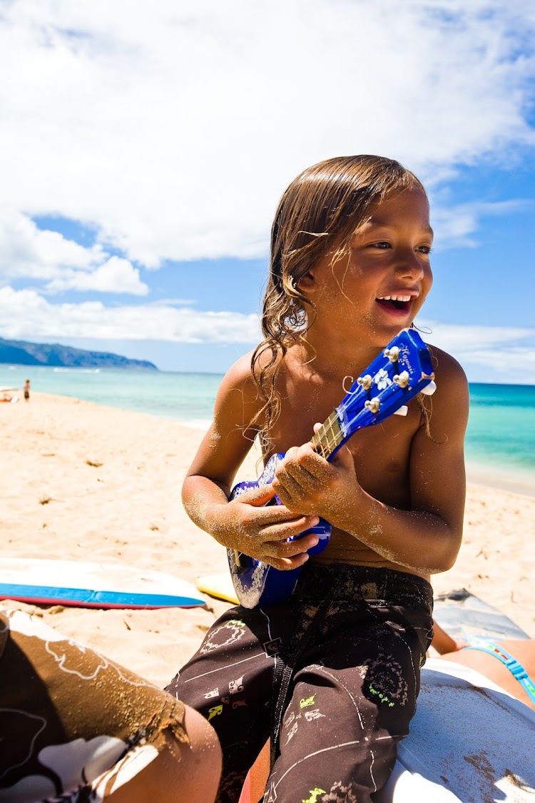 A young local boy plays the ukulele in Hawaii.