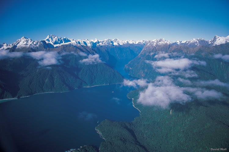 Fiordland’s Milford Sound was carved by glaciers during the ice age. The immense beauty of the area can be appreciated from air or sea — on a cruise ship.  
