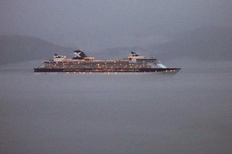 Celebrity Infinity sails through the evening mist of Alaska's Inside Passage, northwest of Ketchikan, as seen from her sister ship, Celebrity Millennium.