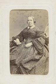 Studioportret van een vrouw in een lange jurk met stippen