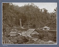 Huizen en waterval langs een spoorbaan in de Anaikloof op Sumatra