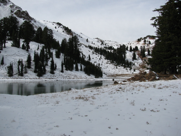 A frozen lake a short way below a ridgeline.