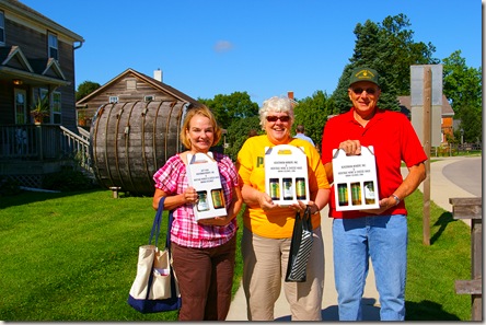 Deanna, Kris and Dennis holding boxes of bottles of wine