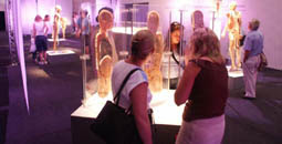 Image shows two ladies looking into an exhibit in a glass case