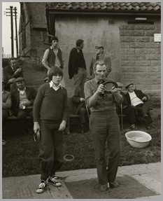 Father and son, Andrew and John White at Fylingthorpe Open North of England Championship on June 9th, 1979.
Mr. White beat Andrew this game to go onto the semi-final against George Hutton of the Fylingthorpe Club.
Andrew will have led off and put a ringer on.  Mr. White is attempting to top the ringer by throwing a flat quoit.