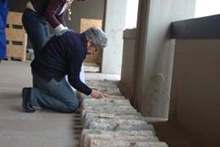 A curator at the National Archaeological Museum in Cagliari checks the ingots after they were retrieved from a Roman shipwreck [NFN/Cagliari Archeological Superintendence]