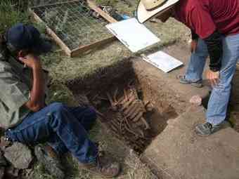 The Blackfeet Tribe's historic preservation officer John Murray, left, and crew member Jesse Ballenger look at bison bones uncovered at the Two Medicine bison jump site on the Blackfeet Indian Reservation.
