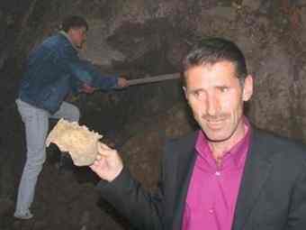 A Turkish local shows part of a skull uncovered in the mass grave