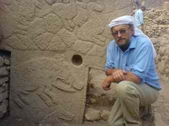 Archaeologist Klaus Schmidt poses next to some of the carvings at Gebekli.