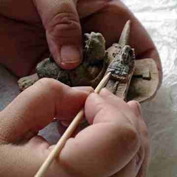 The Scribe King's headdress gets a delicate cleaning from a conservator in Guatemala City. (Courtesy Lynn Grant)