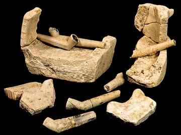 Jamestown pipes sit atop fragments of a sagger, a small, clay, pipemaking oven (Photograph courtesy Michael Lavin, Jamestown Rediscovery).