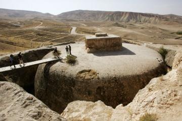 Members of a French archaeological team walk on top of a giant 4th century Buddhist stupa cut into a mountain in Samangan province, Afghanistan, in 2006. A similar historic site to the south and east in Mes Aynak is now at risk from a copper mine. (John Moore/Getty Images) 