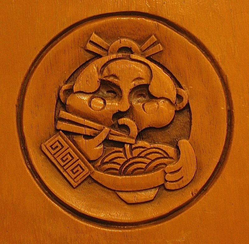 logo of Rai Rai Ken Ramen House and Sushi Bar carved on wooden chair