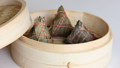 photo of three Rice dumplings in a bamboo steamer