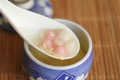 a close-up photo of a spoonful of rice wine soup with fermented rice