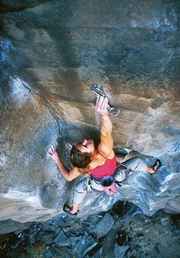 mujer escalando montaña