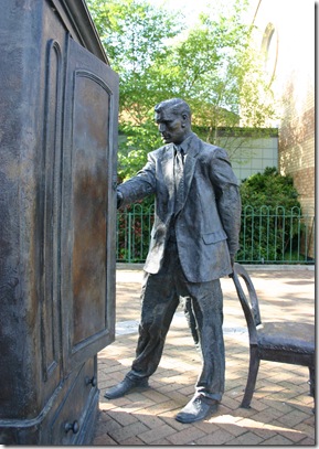Statue of C.S. Lewis looking into a wardrobe. Entitled "The Searcher" by Ross Wilson displayed in Belfast.