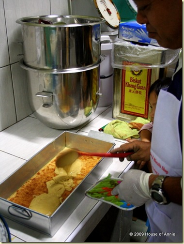ladling batter onto bottom layer of sarawak layer cake - copyright house of annie