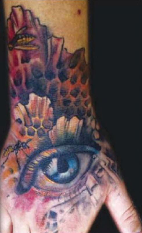 eye tattoo art in the hands of