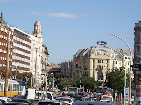 Szirtes András A Károly körút 5/A-ban eladó a város fölé magasodó kis nyolcszögletű torony, legalábbis erre hívja fel a figyelmet a vaskorlátra erősített házilag készült puritán molinó - már ha valakinek véletlenül olyan magasba téved a pillantása. A lepelre felsprézett mobilszám hívása után rögtön kiderül: a hatemeletes épület sarkára a század elején felhúzott építményt Szirtes András filmrendező árulja egy hónapja, és az akciót jókora médiaérdeklődés övezi, a szombatra szervezett ingatlanbejárásra több lap, és egy tévéstáb is bejelentkezett. A tuaregjelmezbe bújt rendezőt nem rázza meg, hogy a tévések végül nem jöttek el, az amúgy sem tágas toronyban így is folyvás összeütközve kerülgetik egymást a panorámától elállt lélegzetű fotósok.