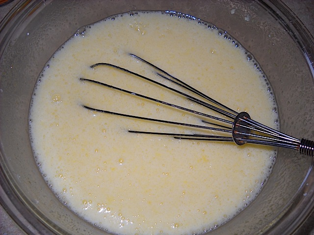 Lemon Bar filling in clear mixing bowl with metal whisk 