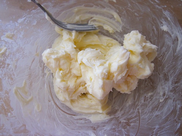 creamed butter and powdered sugar in clear mixing bowl 