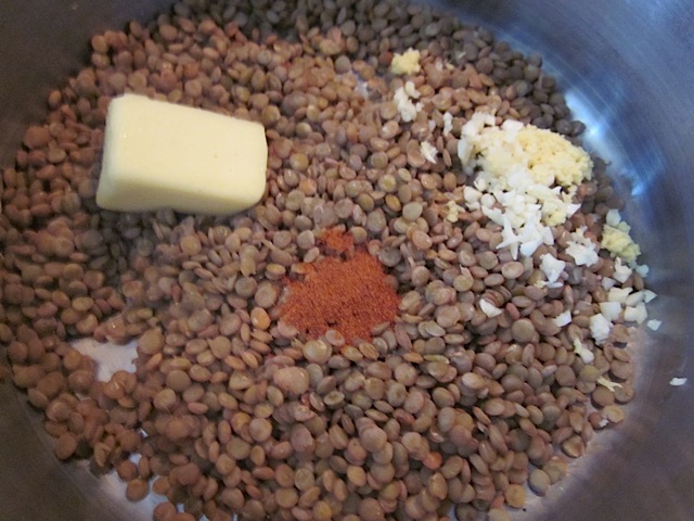 lentils in pot with butter, garlic, ginger, cayenne, cumin, salt and pepper