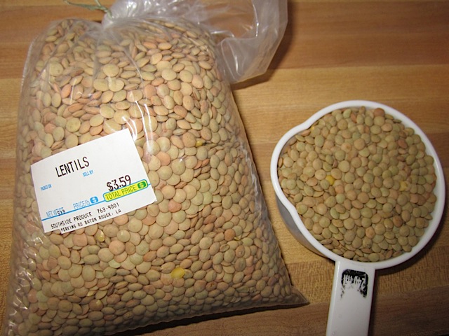 brown lentils in bag with measuring cup full of lentils on side 