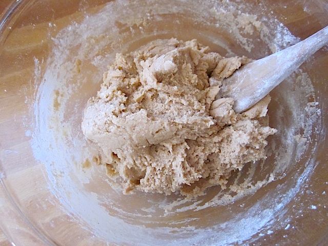 wet and dry ingredients mixed together in bowl with wooden spoon