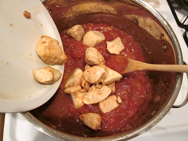 adding chicken back into pot with the tomato sauce ingredients. 