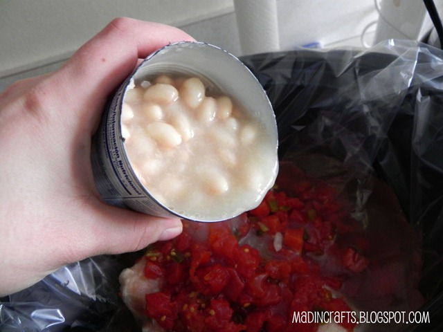 hand pouring white beans into a crockpot