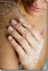 woman applying body scrub in shower