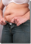 woman with big belly struggling to fit into jeans