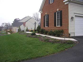 One hardly notices the bed along the front walk of this large home.