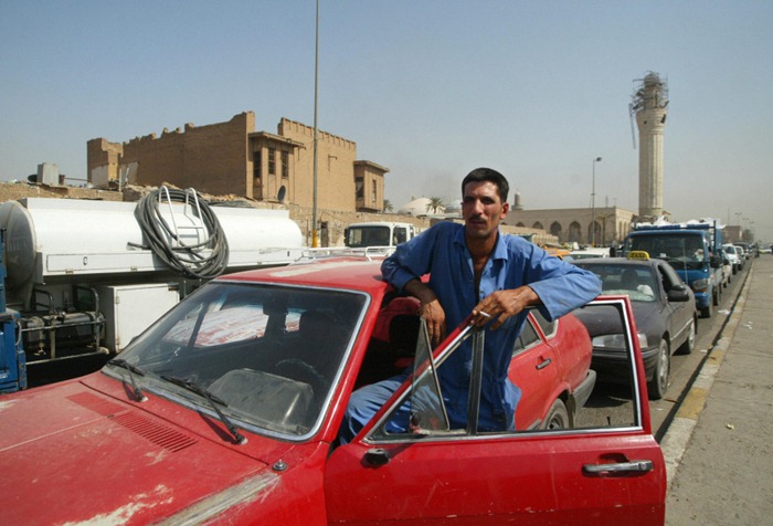 An Iraqi smokes a cigarette out of his car during a traffic jam in central Baghdad, 26 August 2007. Iraq imposed an indefinite curfew on two-wheelers and hand carts in Baghdad and its surrounds yesterday, as thousands of Shiite pilgrims headed to the shrine city of Karbala for a major festival. The curfew came hours after a car bomb in Baghdad's Shiite neighbourhood of Kadhimiyah killed seven people and wounded 30, according to medical and security officials.   AFP PHOTO / ALI YUSSEF (Photo credit should read ALI YUSSEF/AFP/Getty Images)
