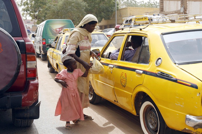 A Displaced Sudanese woman from Darfur holds the hand of her daughter as she begs for money in the traffic jam of Khartoum on February 26, 2008. The deadly conflict in Darfur entered its sixth year today with no solution in sight as Khartoum continued to resist the full deployment of a peacekeeping force amid a fresh wave of bombings. The United Nations said earlier this week that new bombings were endangering thousands of lives in Darfur, seeking reassurances that more civilians would be allowed to flee to join the estimated 2.2 million already displaced by the conflict. AFP PHOTO/ISAM AL-HAJ (Photo credit should read Isam Al-Haj/AFP/Getty Images)