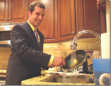 uncool man washing dishes in a suit