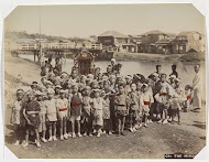 Kinderen met een ceremoniële draagkoets aan de oever van een rivier