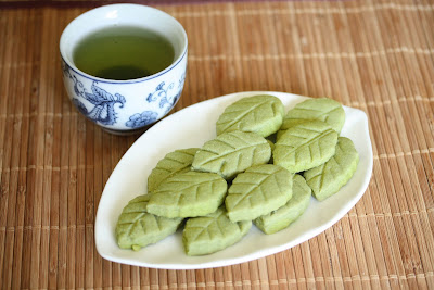 overhead photo of mug of green tea and a plate of cookies
