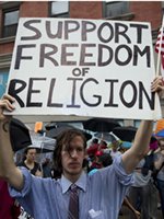 Man holding sign reading 'Support Freedom of Religion'