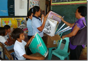 AQD's Ms. Luisa Pacino (right) turning over school supplies to teachers and students of Malalison