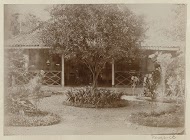Tuin bij een huis met een veranda in Nederlands-Indië
