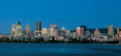 The Montreal skyline over the St. Lawrence River at nightfall.