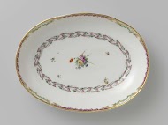 Schaal, diep en ovaal van vorm,behorend bij een servies met geslingerd lintmotief met bladertakken, bloemboeketten en gestrooide bloemtakken