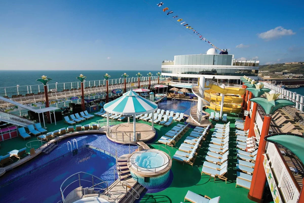 Norwegian-Gem-Pool-Deck - Head to the Tahitian Pool during your Norwegian Gem cruise and enjoy splendid views of the ocean, relaxing lounges, a big pool to swim in and a variety of dining options.