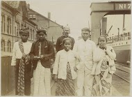 Mannen en vrouwen met een gehelmde politieagent op een kade in een haven