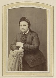 Portret van een vrouw met een muts leunend op een fauteuil